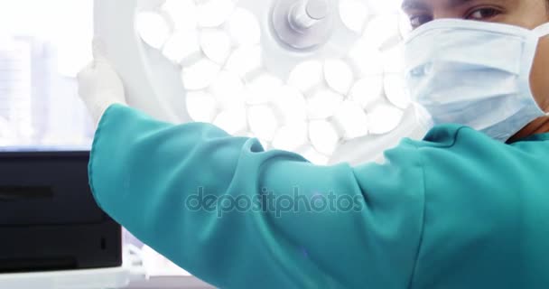 Portrét chirurg úprava chirurgická světla — Stock video