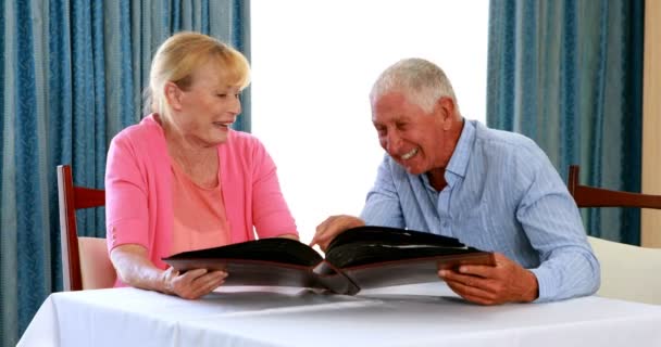 Seniorenpaar schaut sich Fotoalbum an — Stockvideo