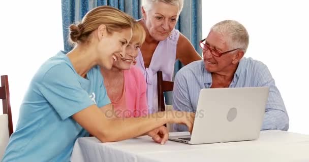 Mulheres voluntárias e idosos usando laptop — Vídeo de Stock