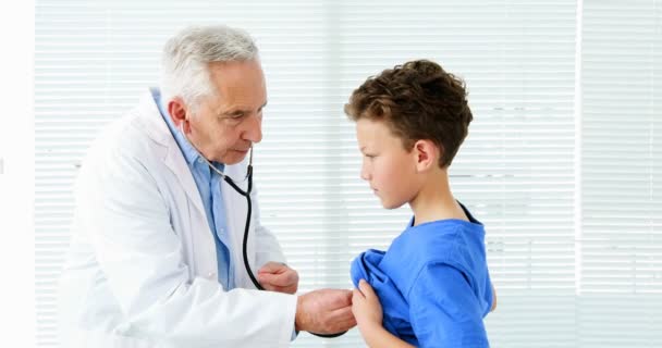 Male doctor examining a boy — Stock Video