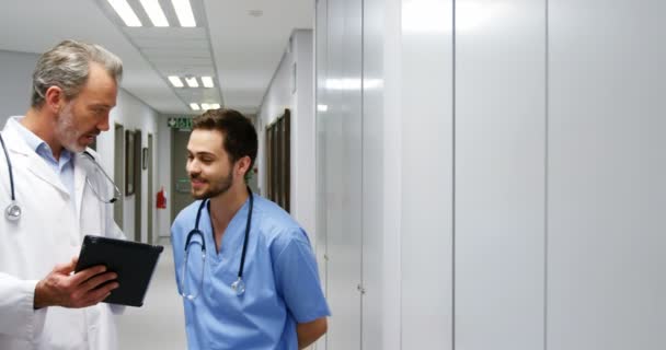 Doctor and colleague discussing over digital tablet — Stock Video