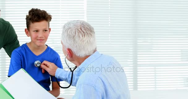 Homme médecin examinant un garçon — Video