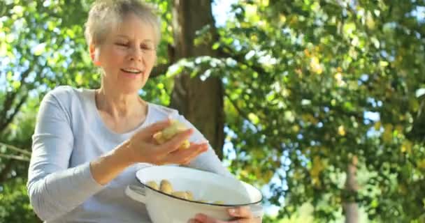 Пожилая женщина показывает картошку — стоковое видео