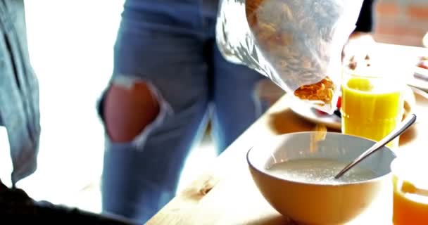Paar gießt Cornflakes in Schüssel — Stockvideo