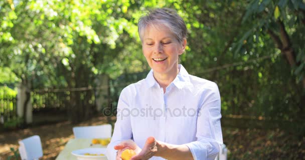 Mujer mayor lanzando limón — Vídeos de Stock