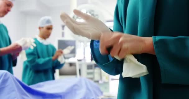 Cirurgiões usando luva cirúrgica — Vídeo de Stock