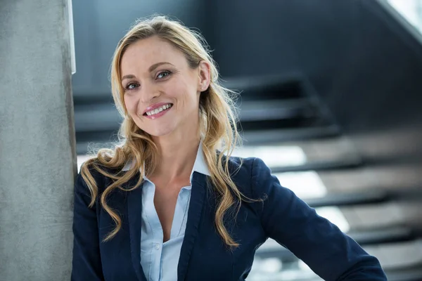Mujer de negocios sonriente de pie en el cargo —  Fotos de Stock