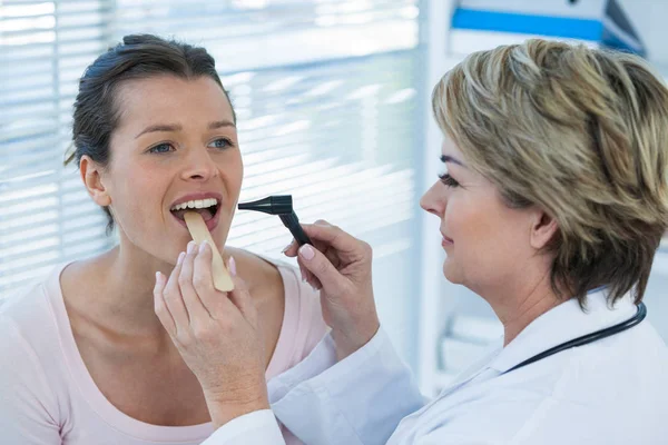 Лікар вивчає зуби пацієнтів з отоскопом — стокове фото
