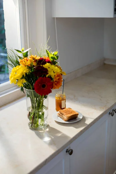 Vaso de flores e pequeno-almoço na bancada — Fotografia de Stock