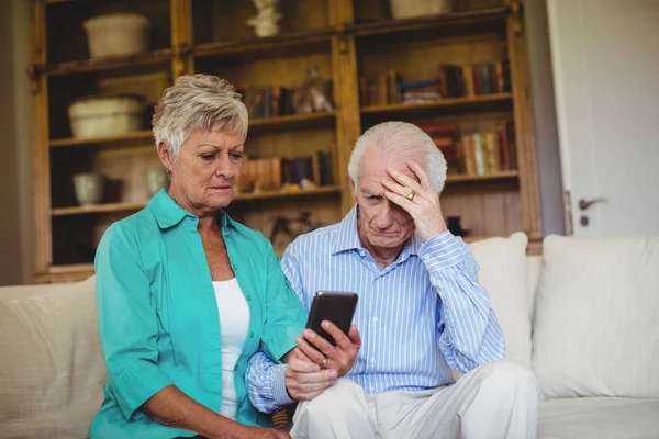 Napjaté starší pár při pohledu na mobilní telefon — Stock fotografie