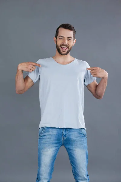 Веселый мужчина, позирующий в серой футболке — стоковое фото