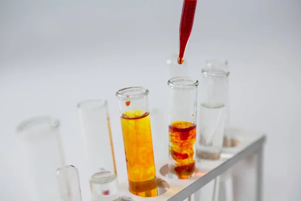 Blood sample being drop into test tubes — Stock Photo, Image