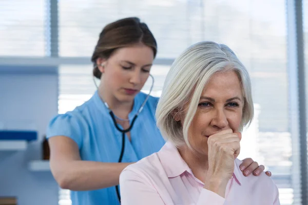 Doctor examining coughing patient — Stock Photo, Image