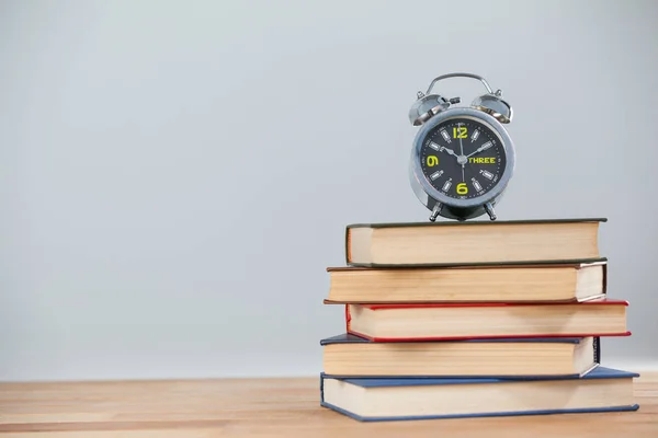 Alarm clock and stack of books — Stock Photo, Image