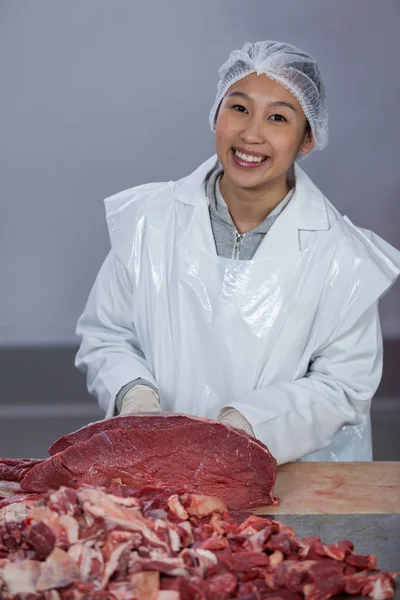 Açougueiro com carne crua na bancada — Fotografia de Stock
