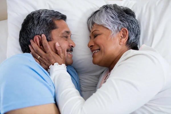 Äldre par avkopplande tillsammans på sängen — Stockfoto