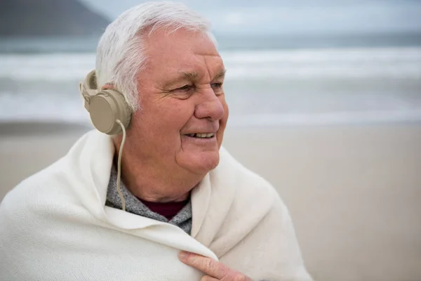 Homem sênior vestindo xale e ouvir música — Fotografia de Stock