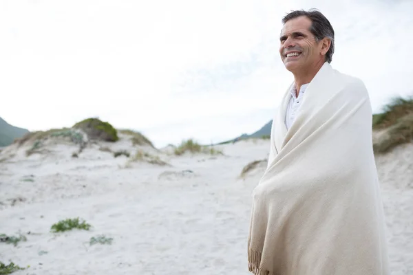 Mann in Schal gehüllt am Strand — Stockfoto