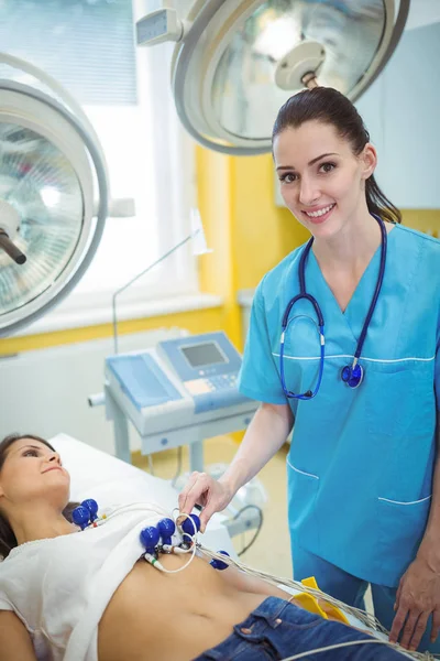 Медсестра, що проводить тест електрокардіограми на пацієнта — стокове фото