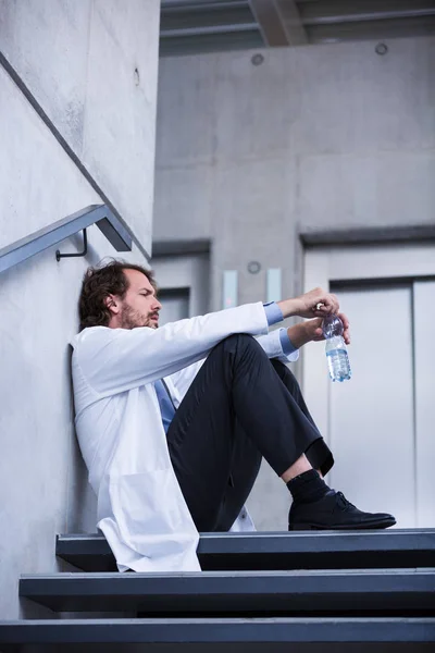 Médecin inquiet assis sur les escaliers — Photo