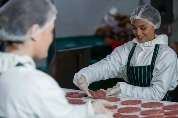 Carniceiros do sexo feminino processamento hambúrguer patty — Fotografia de Stock