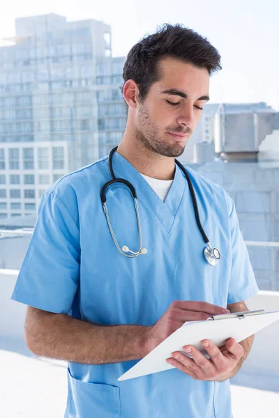 Surgeon writing in clipboard — Stock Photo, Image