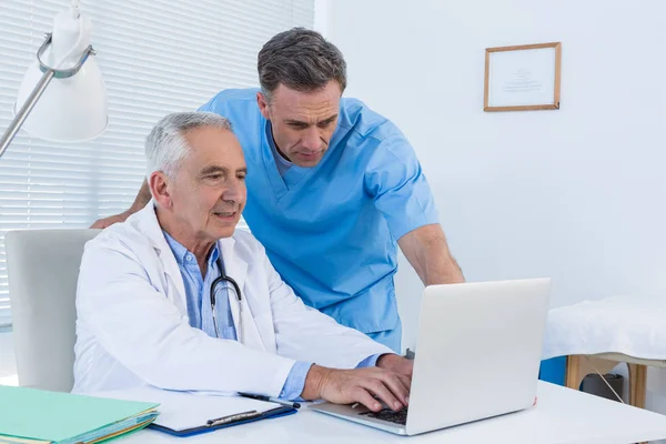 Chirurgien et médecin discutant sur ordinateur portable — Photo