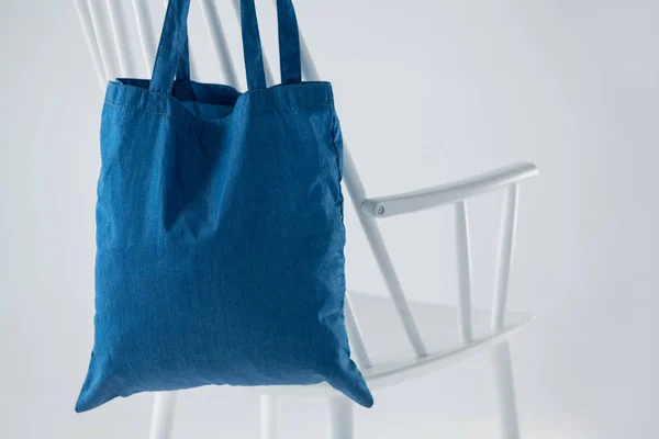 Blaue Tasche hängt auf weißem Stuhl — Stockfoto