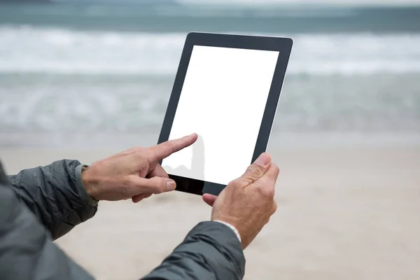 Mies käyttää digitaalinen tabletti rannalla — kuvapankkivalokuva
