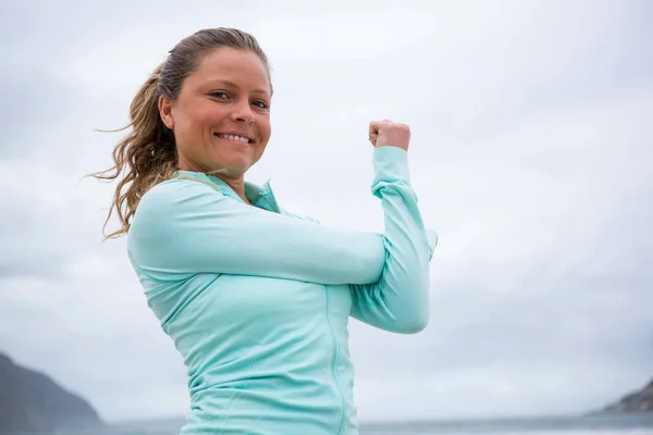 Mujer realizando ejercicio de estiramiento en la playa —  Fotos de Stock