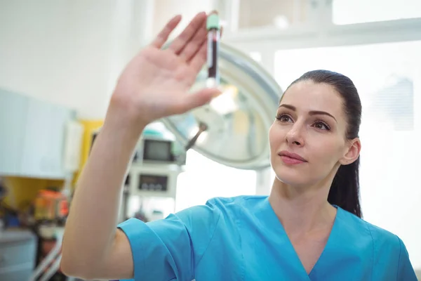 Krankenschwester schaut sich die Blutprobe an — Stockfoto