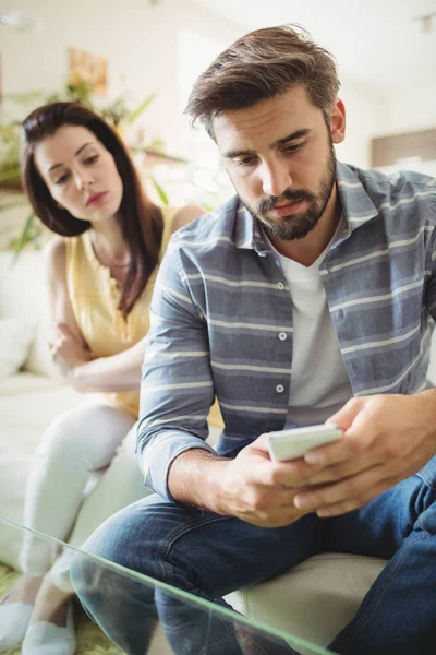 Par med mobiltelefon på soffa — Stockfoto
