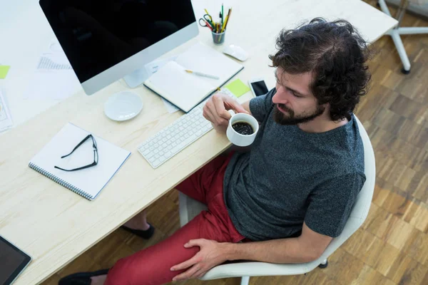 Företagsledare med kaffe vid sitt skrivbord — Stockfoto
