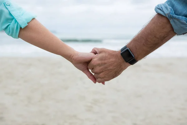 Par som håller händer på stranden — Stockfoto