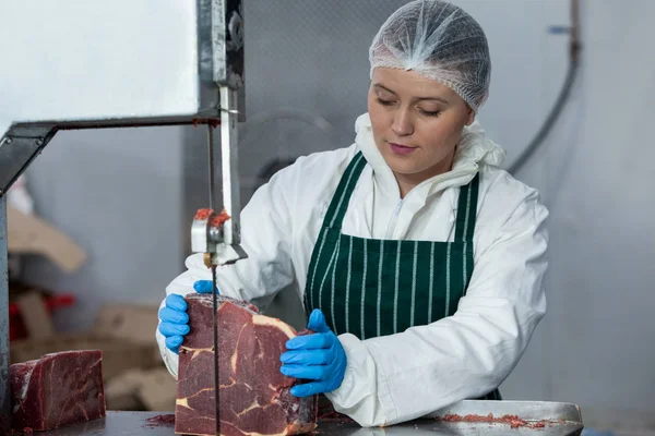 Macellaio femminile che taglia carne cruda — Foto Stock