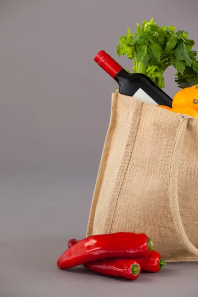 Garrafa de vinho e legumes no saco de supermercado — Fotografia de Stock