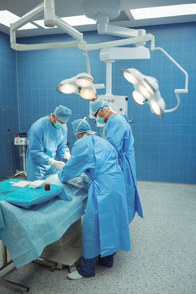 Equipe de cirurgiões realizando operação no teatro de operação — Fotografia de Stock