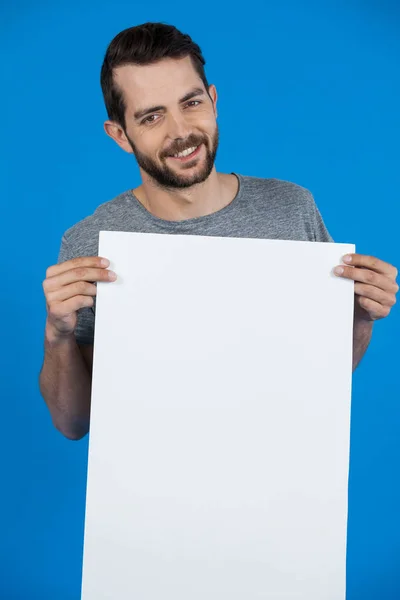 Bonito homem segurando um cartaz em branco — Fotografia de Stock