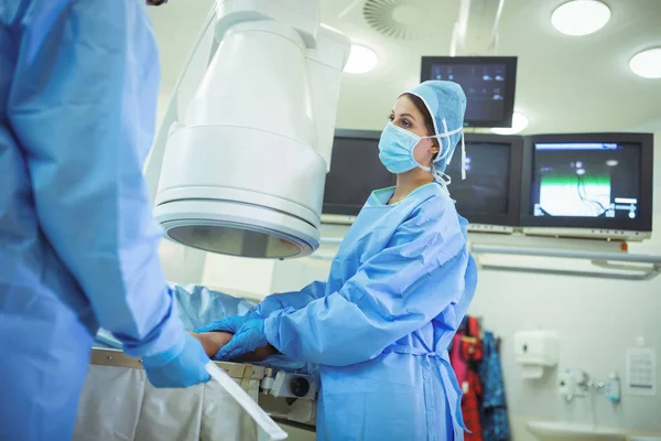 Cirurgiões examinam paciente em sala de operações — Fotografia de Stock
