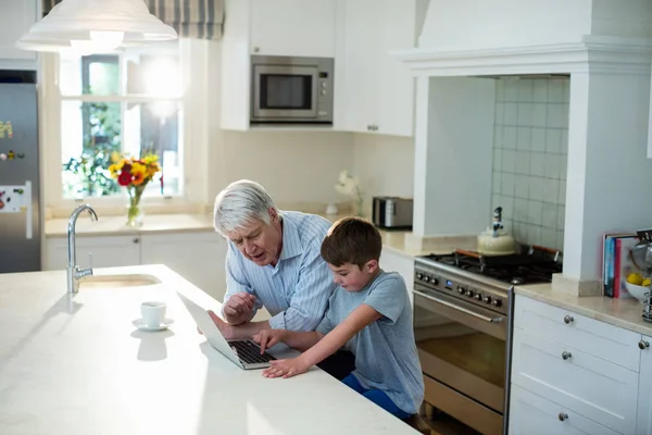 Sonson använder laptop med farfar — Stockfoto