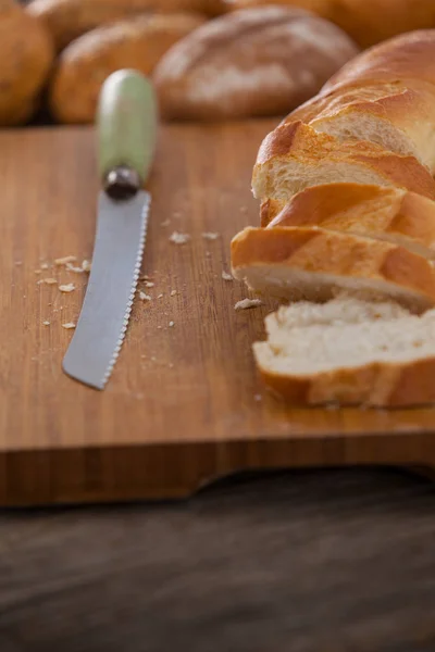 Sliced baguette with knife — Stock Photo, Image