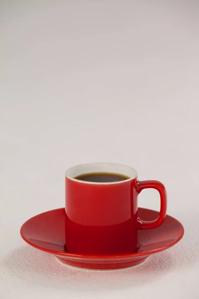 Xícara de café vermelho no pires — Fotografia de Stock