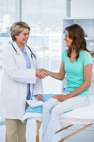 Médico femenino estrechando las manos con el paciente — Foto de Stock