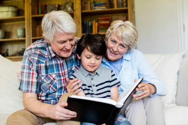 Far-och morföräldrar och barnbarn tittar på fotoalbum — Stockfoto