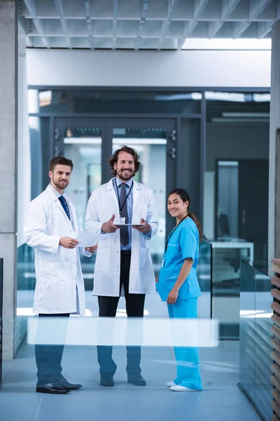 Doctor sosteniendo la tableta de pie con sus colegas — Foto de Stock