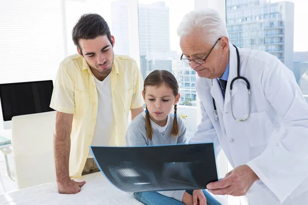 Доктор обсуждает рентгеновский отчет с отцом и дочерью — стоковое фото