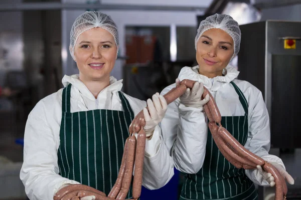 Metzgerinnen verarbeiten Wurst — Stockfoto