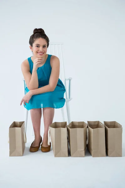 Frau sitzt mit Einkaufstüten — Stockfoto