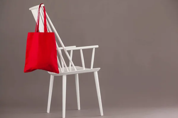 Red bag hanging on a white chair — Stock Photo, Image