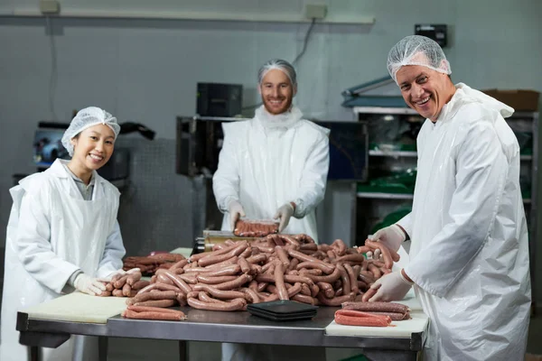 Butchers processing sausages — Stock Photo, Image